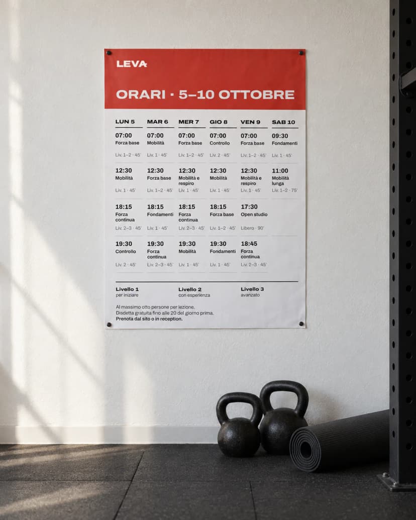 Calendario A3 Leva appeso alla parete di una sala d'allenamento, con due kettlebell a terra
