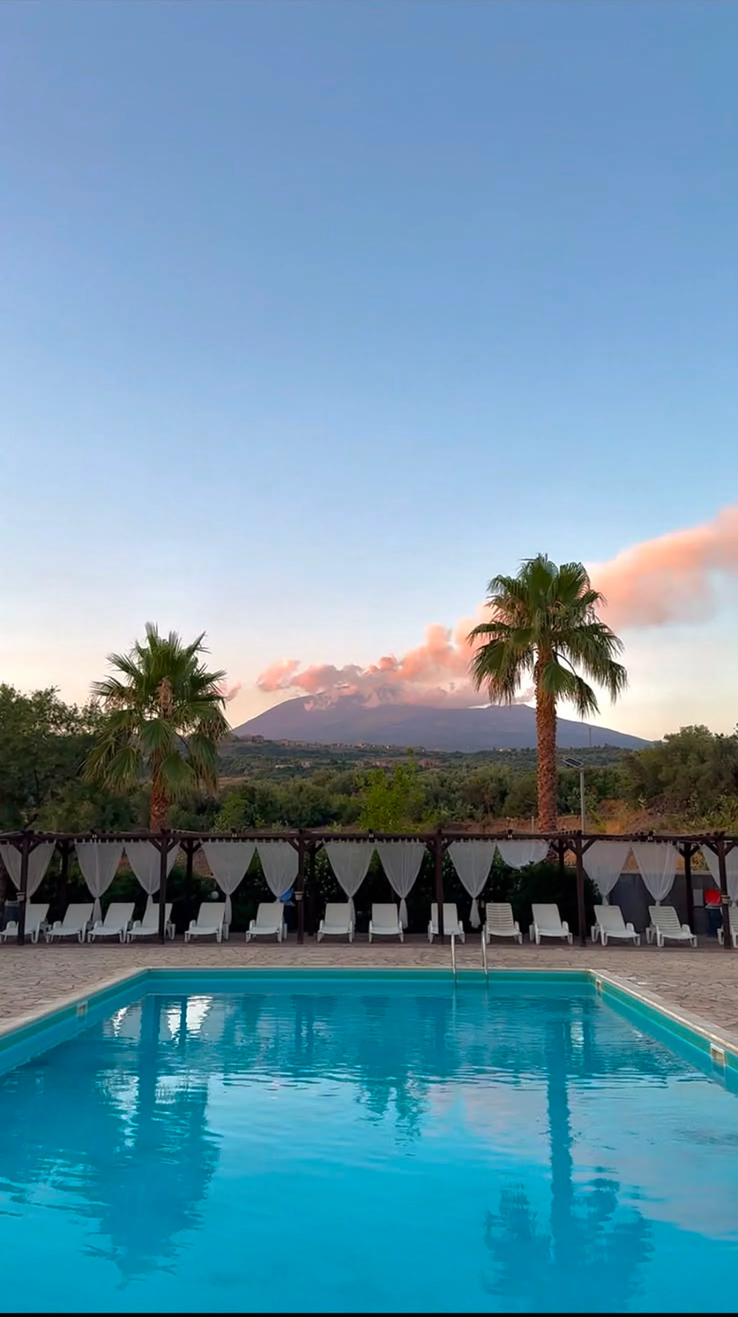 L'Etna al tramonto dalla piscina, fra due palme